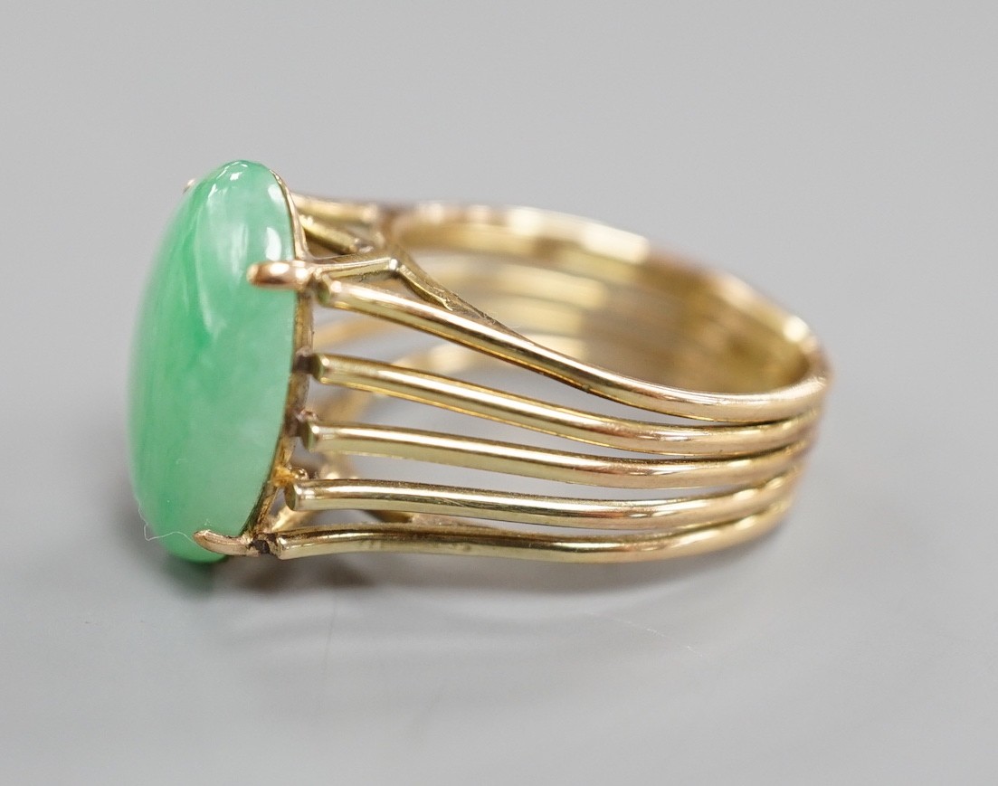 A 585 yellow metal and cabochon jade set oval dress ring, size P/Q, gross weight 8.4 grams.